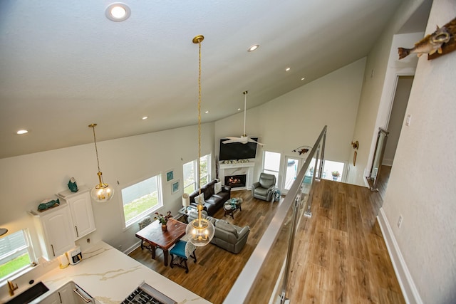 living room with ceiling fan, recessed lighting, a fireplace, wood finished floors, and high vaulted ceiling