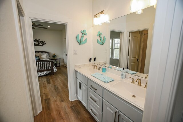 bathroom featuring double vanity, connected bathroom, wood finished floors, and a sink