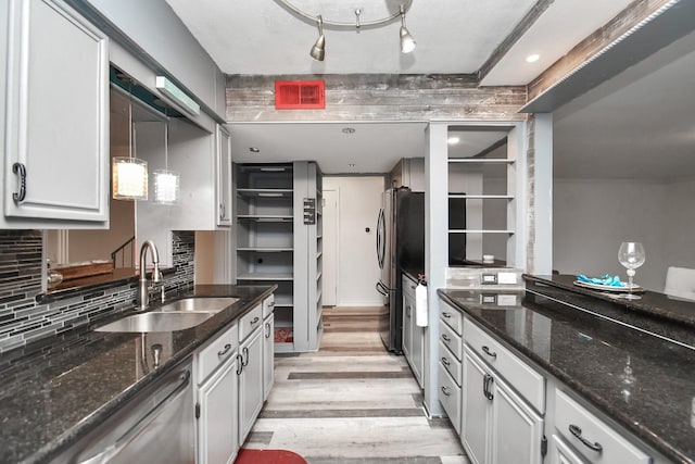 11525 Burdine St Unit 421, Houston, TX 77035 - kitchen featuring dark stone countertops, light wood finished floors, a sink, appliances with stainless steel finishes, and tasteful backsplash