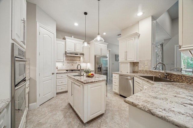 4106 Tee Tree Ct, Spring, TX 77386 - kitchen featuring stainless steel appliances, a sink, decorative backsplash, recessed lighting, and under cabinet range hood