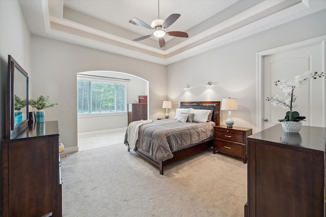 4106 Tee Tree Ct, Spring, TX 77386 - bedroom featuring light carpet, a tray ceiling, baseboards, a ceiling fan, and arched walkways