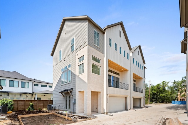2932 Michaux St, Houston, TX 77009 - rear view of property with board and batten siding, central AC, and an attached garage
