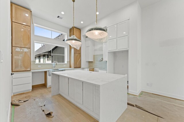 2932 Michaux St, Houston, TX 77009 - kitchen with tasteful backsplash, a kitchen island, a sink, white cabinetry, and recessed lighting