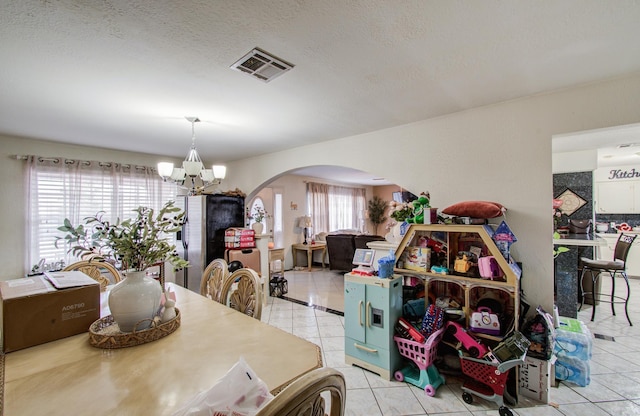 1421 Glenmore Forest St, Houston, TX 77055 - dining area with arched walkways, a notable chandelier, tile patterned flooring, and visible vents