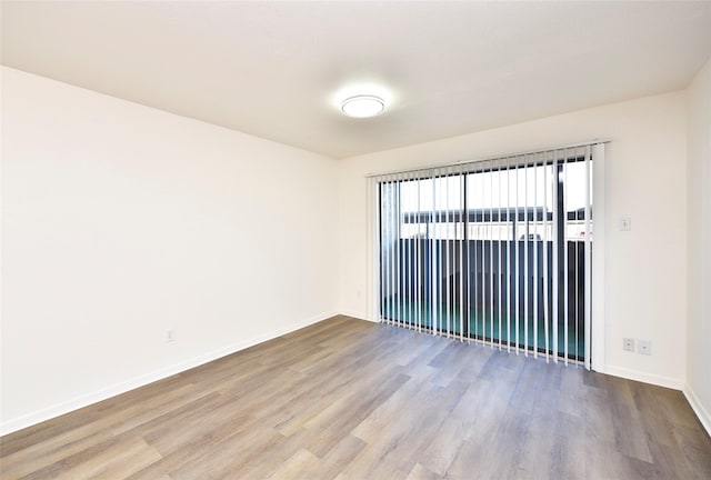 spare room featuring wood finished floors and baseboards