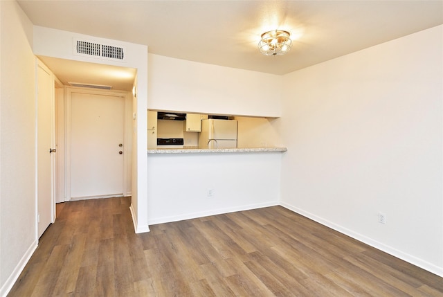 unfurnished room featuring dark wood-type flooring and baseboards