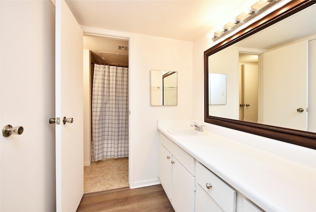 full bath with wood finished floors, vanity, baseboards, and a shower with curtain