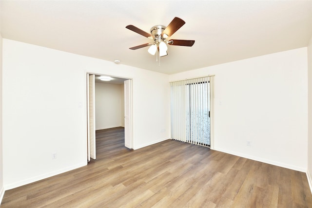 empty room featuring light wood-style floors, ceiling fan, and baseboards