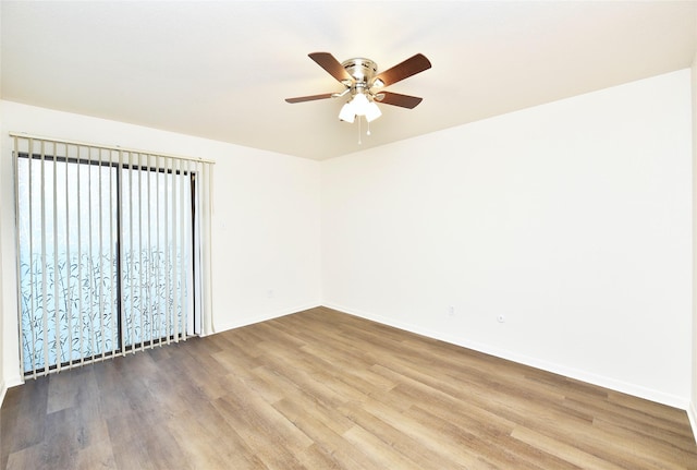 unfurnished room with a ceiling fan, wood finished floors, and baseboards