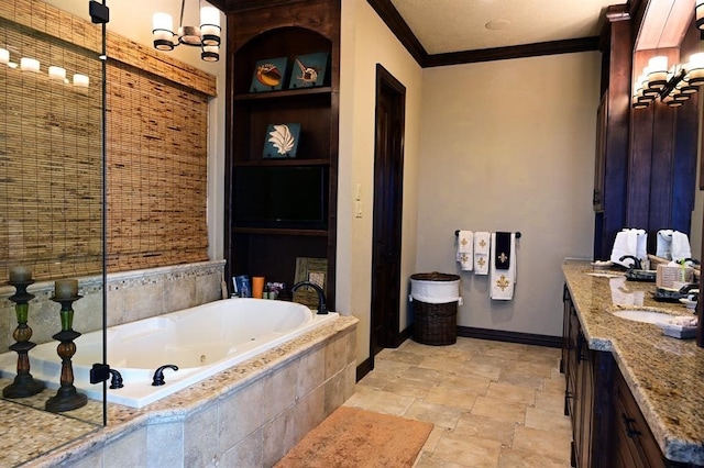 bathroom with vanity, baseboards, ornamental molding, stone finish flooring, and a jetted tub