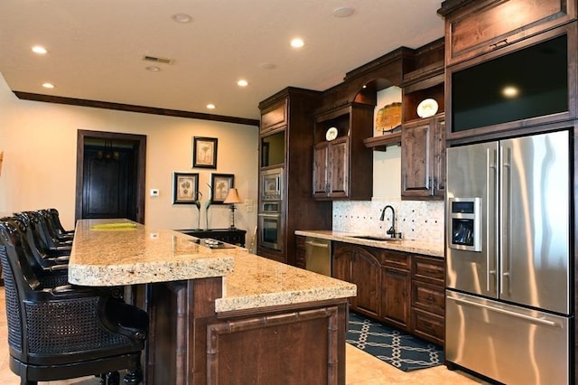 kitchen with a sink, backsplash, dark brown cabinetry, and appliances with stainless steel finishes