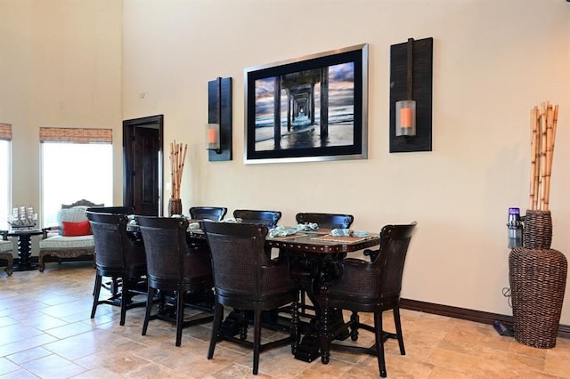 dining area with a high ceiling and baseboards