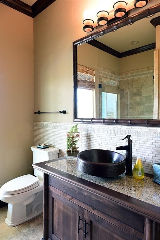 bathroom featuring tasteful backsplash, crown molding, toilet, tile patterned floors, and vanity