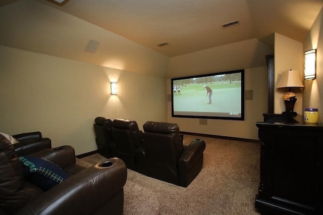 carpeted home theater with visible vents, baseboards, and vaulted ceiling