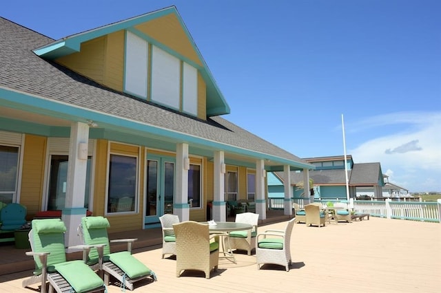 view of patio with a deck, outdoor dining space, and fence