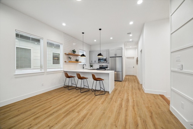 3504 Delhi St B, Unit A, Houston, TX 77022 - kitchen with appliances with stainless steel finishes, a peninsula, a breakfast bar area, open shelves, and light countertops