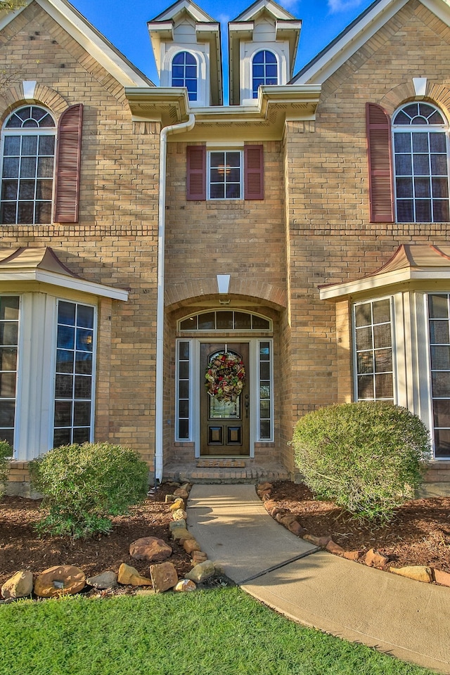 view of exterior entry with brick siding