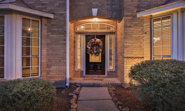 entrance to property featuring brick siding
