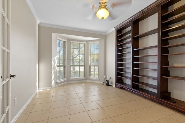 spare room featuring light tile patterned floors, ornamental molding, baseboards, and built in shelves