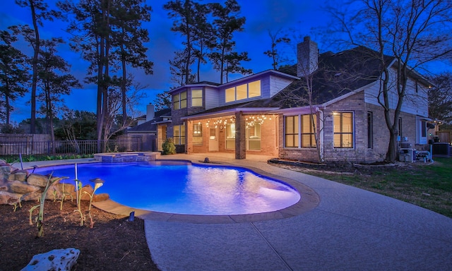 view of pool featuring fence, a pool with connected hot tub, and a patio area