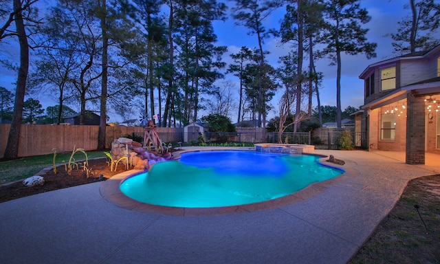 view of swimming pool featuring a fenced backyard, a pool with connected hot tub, and a patio