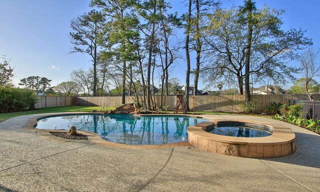 view of swimming pool with a fenced backyard, a pool with connected hot tub, and a patio