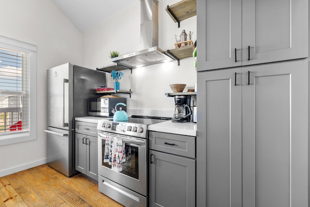 1072 Johnson Rd, Gilchrist, TX 77617 - kitchen with open shelves, appliances with stainless steel finishes, range hood, gray cabinetry, and light wood finished floors