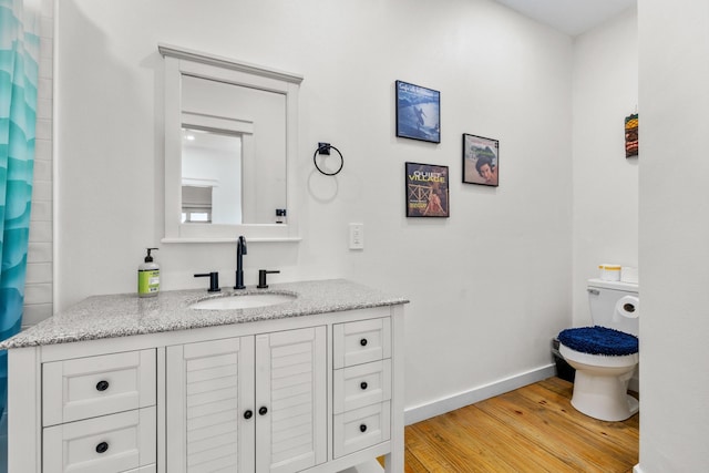 1072 Johnson Rd, Gilchrist, TX 77617 - bathroom featuring wood finished floors, baseboards, vanity, and toilet
