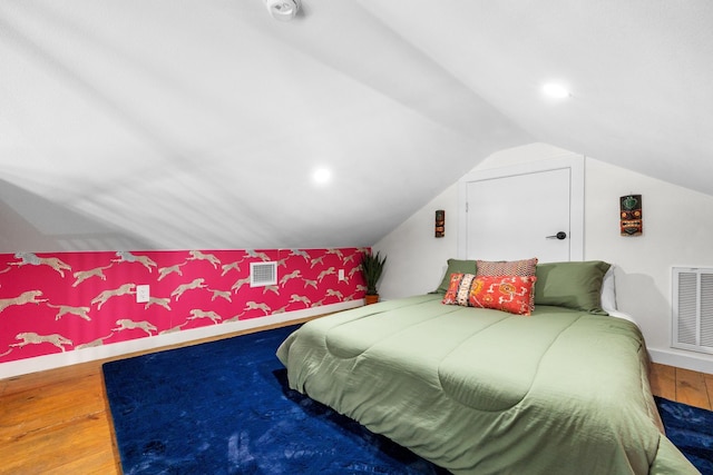 1072 Johnson Rd, Gilchrist, TX 77617 - bedroom featuring wood finished floors, vaulted ceiling, and wallpapered walls