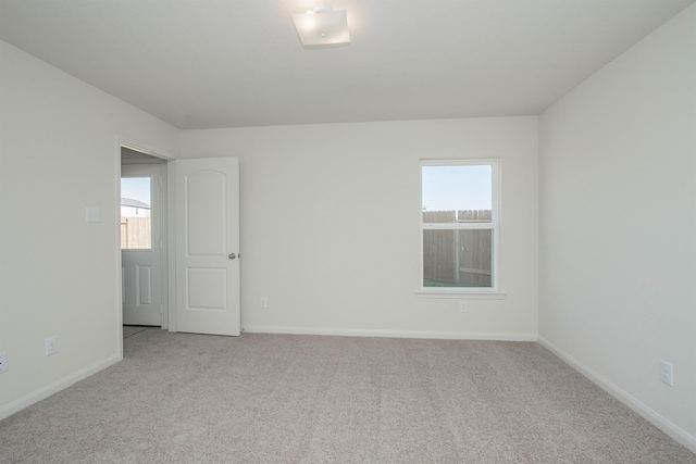 carpeted spare room featuring baseboards