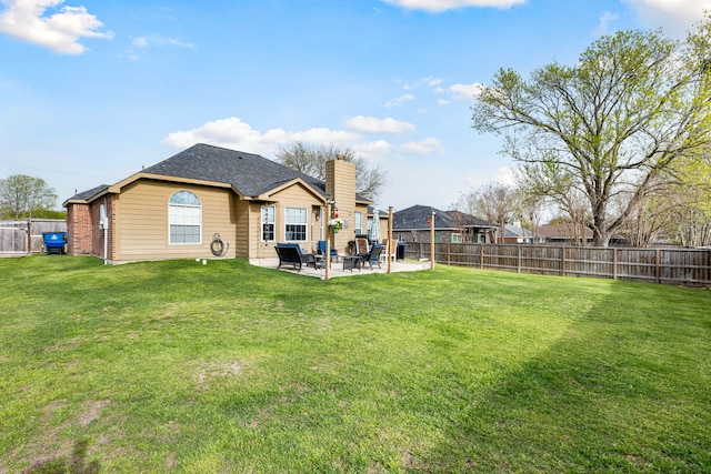back of property with a patio area, a fenced backyard, and a yard