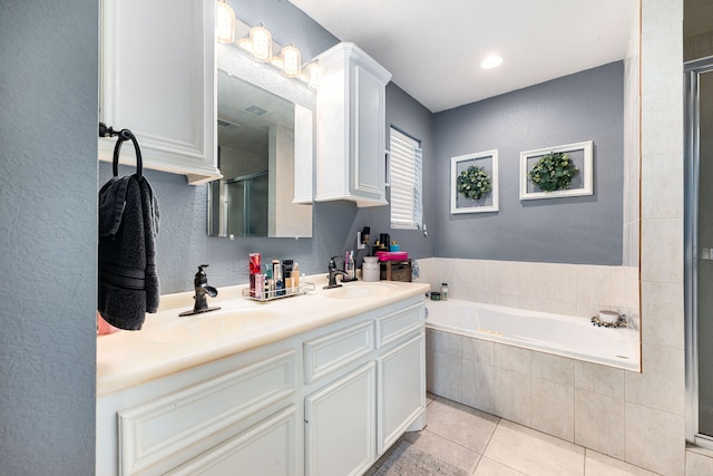 full bathroom featuring a stall shower, a garden tub, a sink, and tile patterned flooring