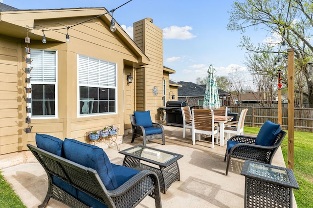 view of patio with area for grilling, outdoor dining space, an outdoor hangout area, and fence