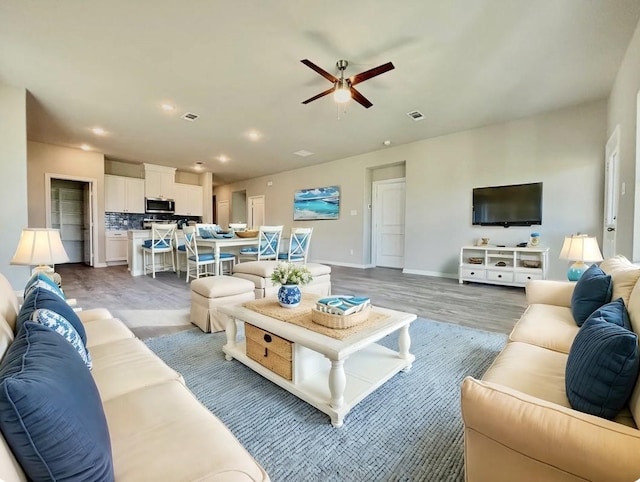 living room with recessed lighting, visible vents, wood finished floors, and ceiling fan