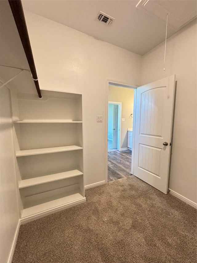 spacious closet with attic access, carpet, and visible vents