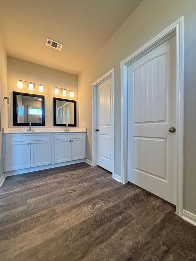 full bathroom with wood finished floors, baseboards, visible vents, double vanity, and a sink