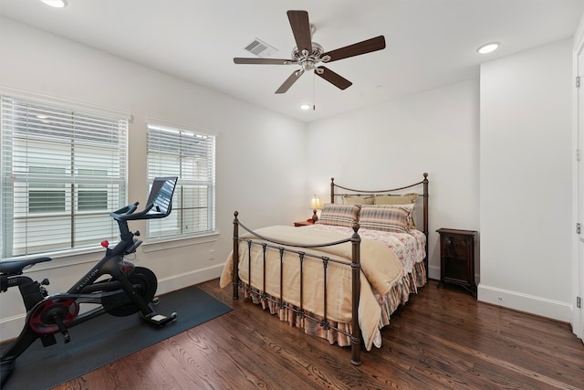 bedroom with baseboards, wood finished floors, visible vents, and recessed lighting