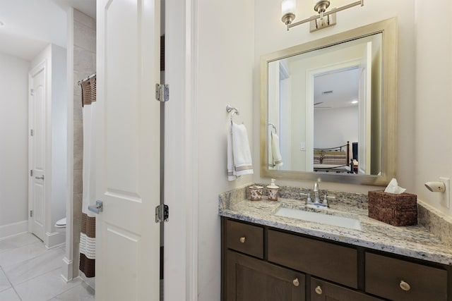 bathroom featuring vanity, a shower with curtain, baseboards, toilet, and tile patterned flooring