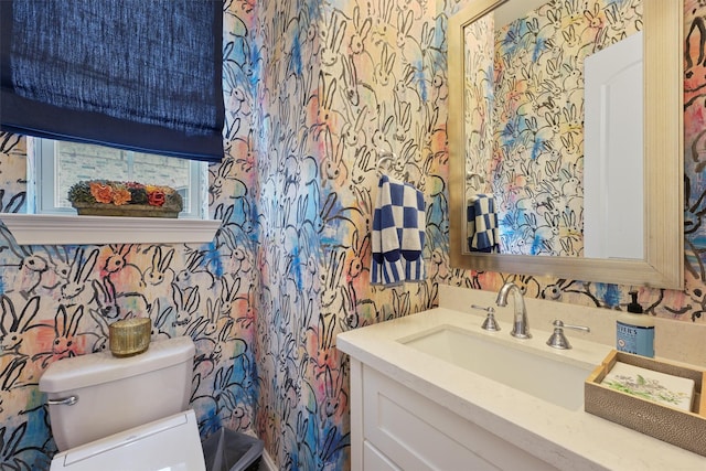 bathroom with wallpapered walls, vanity, and toilet