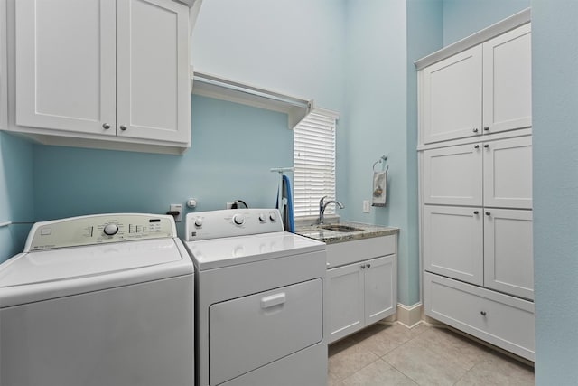 washroom with washing machine and dryer, cabinet space, a sink, and light tile patterned flooring