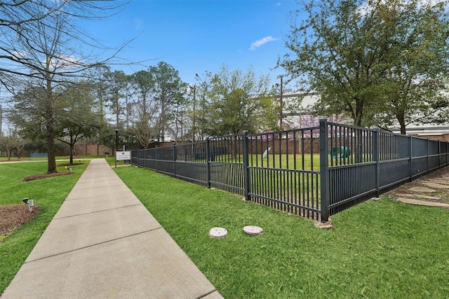 view of home's community featuring fence and a yard
