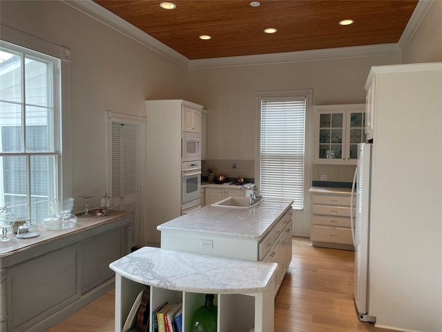 kitchen with a sink, backsplash, a kitchen island, white appliances, and wood ceiling