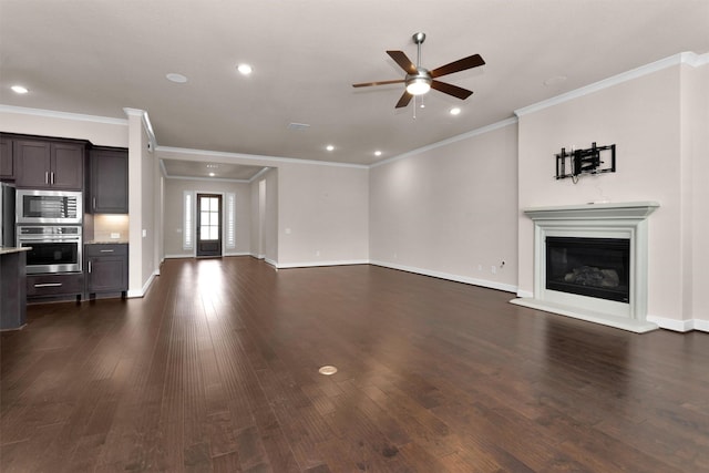 122 S Wild Petunia Trl, Montgomery, TX 77316 - unfurnished living room featuring a ceiling fan, a glass covered fireplace, crown molding, dark wood-style floors, and baseboards