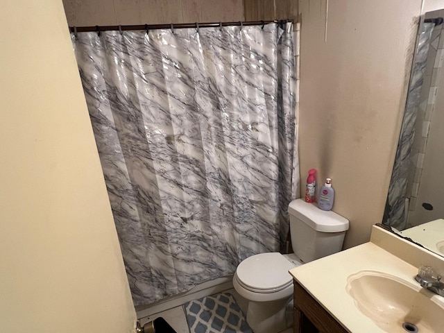 bathroom with toilet, vanity, and curtained shower