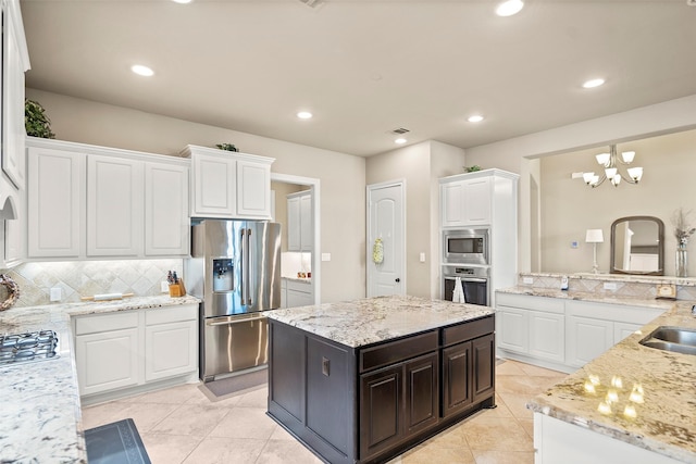 30614 Indigo Falls Dr, Brookshire, TX 77423 - kitchen with stainless steel appliances, tasteful backsplash, light stone counters, light tile patterned floors, and white cabinets
