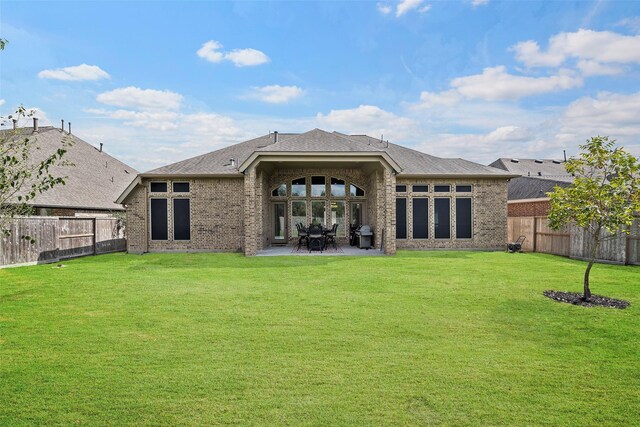 30614 Indigo Falls Dr, Brookshire, TX 77423 - rear view of property with a yard, brick siding, a patio area, and a fenced backyard