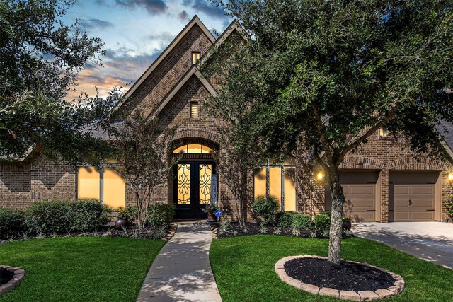 30614 Indigo Falls Dr, Brookshire, TX 77423 - view of front facade with driveway, french doors, brick siding, a garage, and a front yard
