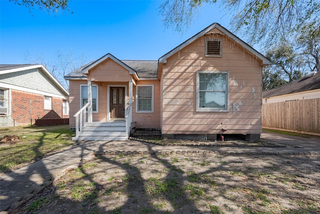 bungalow featuring fence