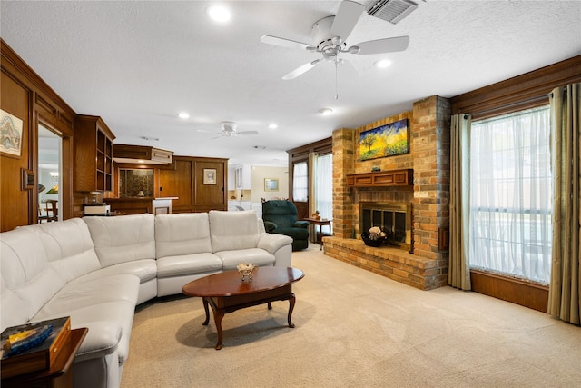 living area with a ceiling fan, light colored carpet, visible vents, a fireplace, and recessed lighting