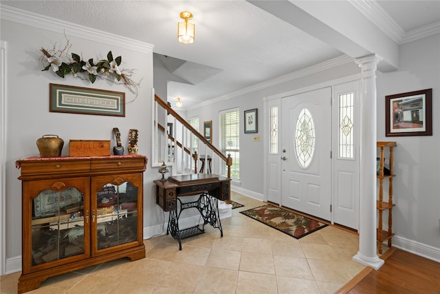 entrance foyer with crown molding, decorative columns, baseboards, and stairway